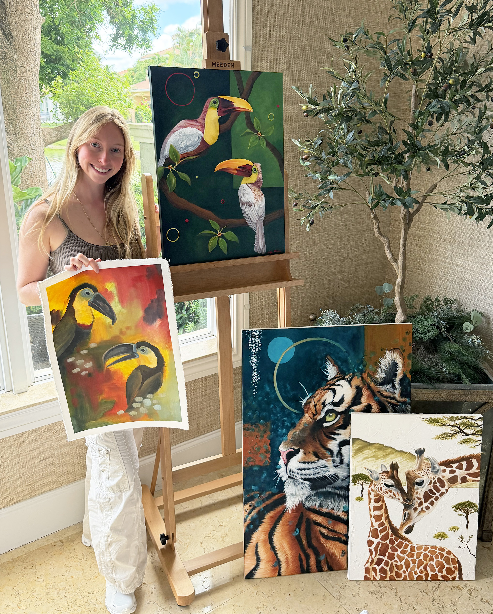 Lily Rivere holding many of her art pieces